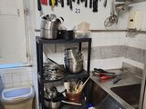 pots and pans on a shelf in a kitchen with a sink
