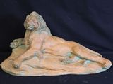 sculpture of a lion laying down on a black background
