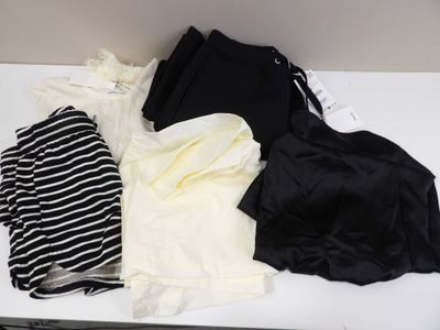a pile of clothes sitting on a table next to a laptop