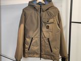 une veste marron accrochée à un porte-manteau dans une pièce