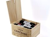 bottles of wine are in a wooden box on a white surface