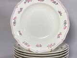 plusieurs assiettes empilées les unes sur les autres, ornées de fleurs roses