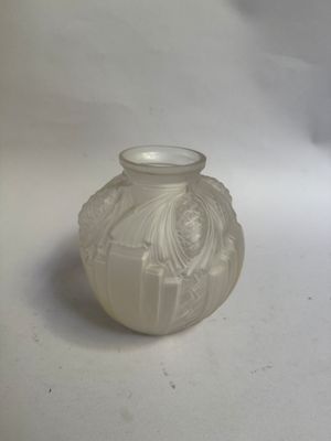 un petit vase blanc posé sur une surface blanche