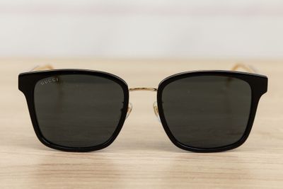 a pair of black sunglasses sitting on top of a wooden table