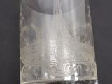 un verre transparent orné d'une tour, posé sur une table