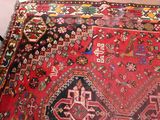 a red rug on the floor next to a black chair
