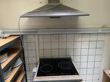 une cuisinière au milieu d'une cuisine, avec des assiettes sur le plan de travail