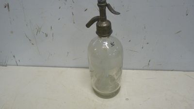 une bouteille en verre munie d'un bec verseur en métal, posée sur un comptoir