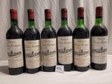 six bottles of wine are lined up on a table