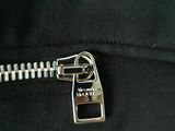 a close up of a zipper on a black shirt with a silver zipper