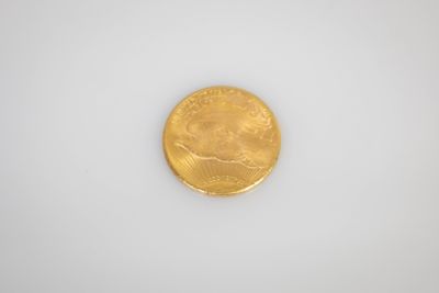 une pièce d'or posée sur une surface blanche