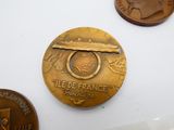 une médaille d'or sur laquelle figure le portrait d'un homme