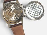 a watch that is sitting next to a grinder
