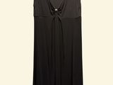 the black dress is hanging on a hanger on a white wall