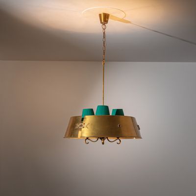 a gold and green chandelier hanging from the ceiling
