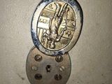 a picture of a metal button with a picture of a ship on it