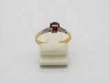 a close up of a gold ring with a red stone on it