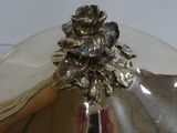 a silver plate with a flower on it on a table