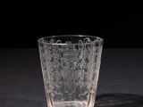 a close up of a glass on a table with a black background