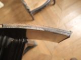 a close up of a chair that has a wooden seat