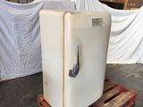 a white refrigerator sitting on a pallet in a warehouse