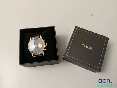 une image montrant un gros plan d'une montre dans un coffret posé sur une table