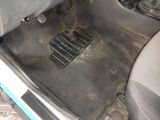 a dirty car floor with a dirty floor mat on it