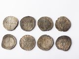 six pièces d'argent de tailles et de formes variées sur un fond blanc