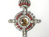 an image of a silver cross with red and white stones on it