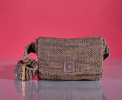 an image of a purse on a table with a pink background