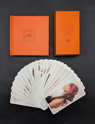 un livre orange sur lequel figure l'image d'une femme à côté d'une pile de cartes à jouer
