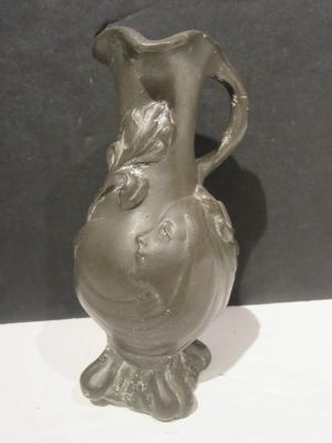 a gray vase that is sitting on a white table