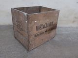 a wooden crate sitting on the floor in front of a wall