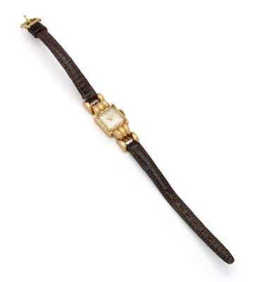 a gold and leather wrist watch with a white dial