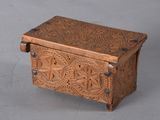 carved wooden box on grey background with metal handles