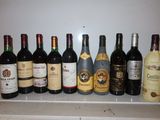 Des bouteilles de vin sont alignées sur une étagère dans une cuisine.