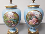 two blue vases with pictures of people on them sitting on a table