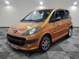 une photo d'une petite voiture orange garée dans un garage