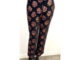 Le pantalon est noir et doré, avec un motif dessus.