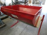 une grande boîte rouge posée sur un support dans un garage