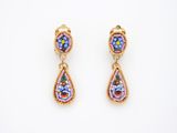 une paire de boucles d'oreilles roses et bleues sur fond blanc