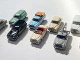 several toy cars are lined up in a row on a white surface
