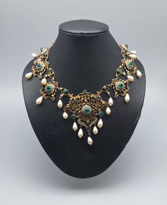 un collier vert et blanc orné de perles sur un mannequin noir