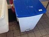 a blue trash can and a white trash can on the floor