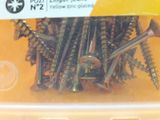 many screws in a plastic container with a label on it