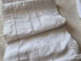 a pile of folded towels on a bed next to a pair of scissors