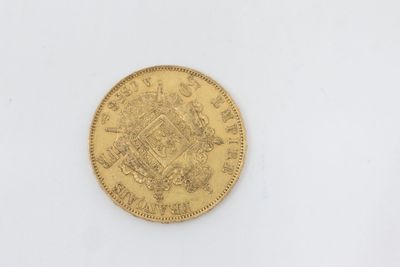 a close up of a gold coin on a white surface