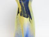 a blue and yellow vase sitting on a white surface