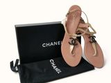 chanel sandals in a box with a black bag and a pair of them