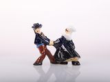 two figurines of a man and a woman holding hands